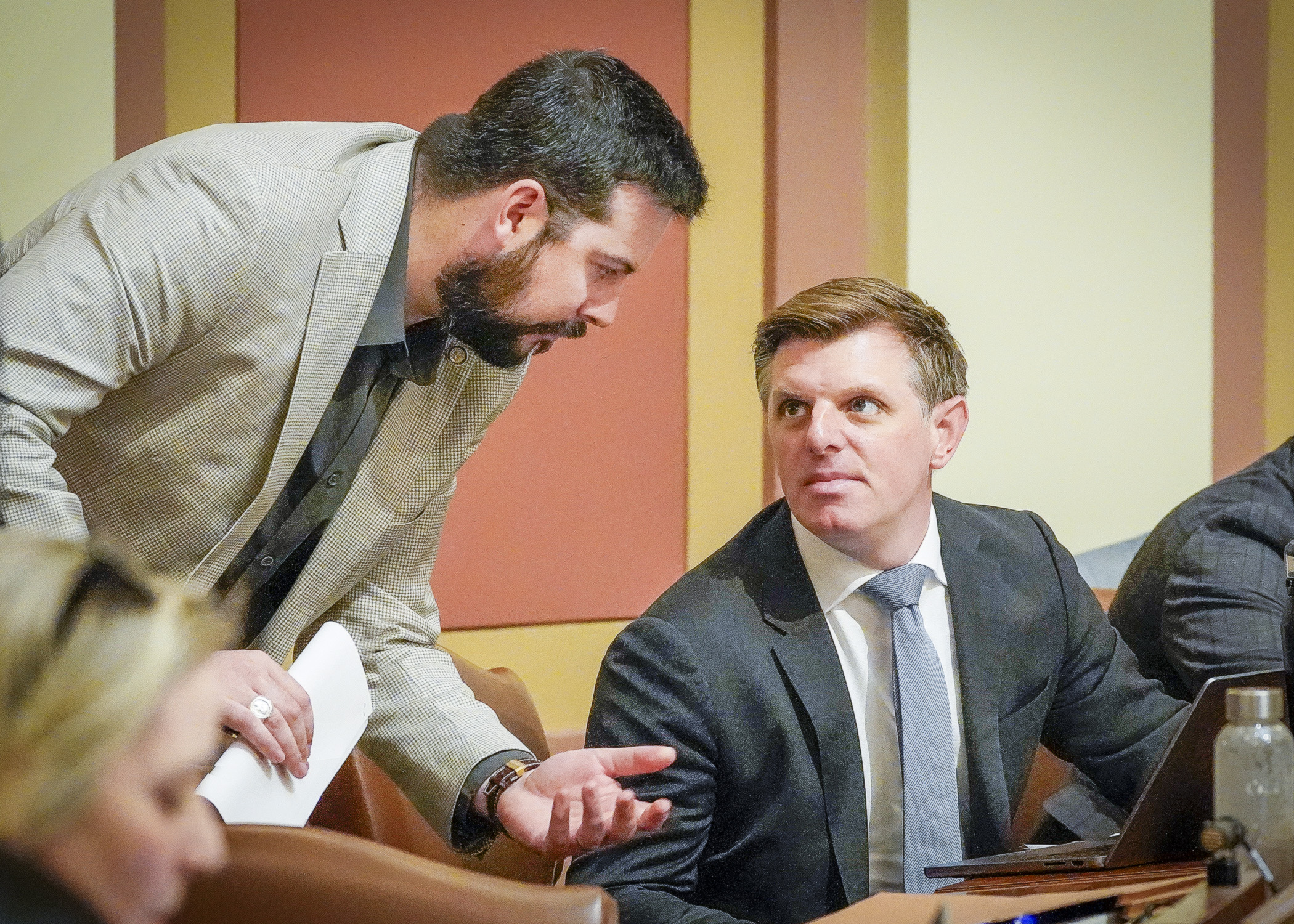 Rep. Spencer Igo and Rep. Michael Howard, co-chairs of the House Housing Finance and Policy Committee, confer on the House Floor May 18 before the omnibus housing conference committee report is brought up for a vote. (Photo by Andrew VonBank)